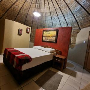a bedroom with a bed in a room with a ceiling at Mountain Aloe Den in Barberton