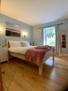 a bedroom with a large bed with a window at Ewich House B&B in Crianlarich