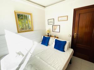 - une chambre avec un lit blanc et des oreillers bleus dans l'établissement Captains Jack Home, à Sitges