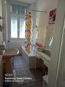 a bathroom with a shower curtain and a sink at Casa di Alice in Gorizia