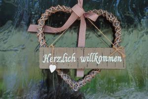 a heart shaped wreath with a sign on a wall at Gästehaus Kuchler in Lam