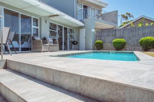 a swimming pool in front of a house at Harbour Cottages, Humewood in Port Elizabeth