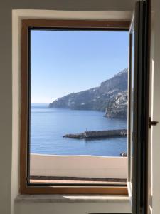 a window with a view of a body of water at Infinity Sea View House in Amalfi