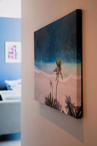 a picture of a beach with a palm tree on a wall at Harbour Cottages, Humewood in Port Elizabeth