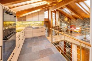 eine Küche mit Holzschränken und eine Treppe in einem Zimmer in der Unterkunft Haus Genepy in Zermatt