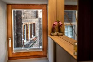 a room with a window with flowers on a ledge at Haus Genepy in Zermatt