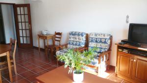 a living room with two chairs and a tv at Sesimbra Concept in Sesimbra