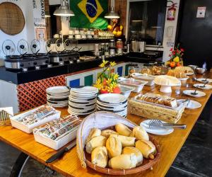 a table with bread and other food on it at Vila Aju - Pousada Temática in Aracaju