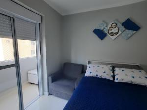 1 dormitorio con 1 cama, 1 silla y 1 ventana en Real Pé na Areia - José Menino/ Santos en Santos