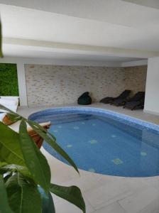 a swimming pool in a house with a plant at Ursuletul Predeal in Predeal