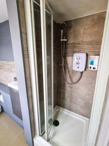 a shower with a glass door in a bathroom at New Refurb Top Floor Flat in Central Cheltenham in Cheltenham