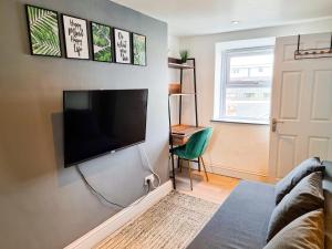 a living room with a flat screen tv on a wall at New Refurb Top Floor Flat in Central Cheltenham in Cheltenham