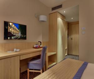 Pokój hotelowy z biurkiem i łóżkiem w obiekcie Bristol Art & Medical SPA w Busku Zdroju