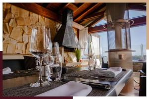 - une cuisine avec des verres à vin sur une table dans l'établissement Auberge de Duillier, à Duillier