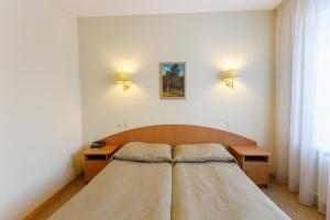 1 dormitorio pequeño con 1 cama y 2 mesas en Hotel Atal, en Cheboksary