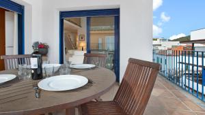 une table et des chaises en bois sur un balcon dans l'établissement 1Kim01 - Llafranc, à Llafranc