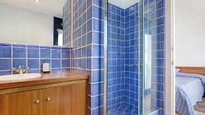 une salle de bain carrelée bleue avec un lavabo et une douche dans l'établissement 1Kim01 - Llafranc, à Llafranc 20 autres photos