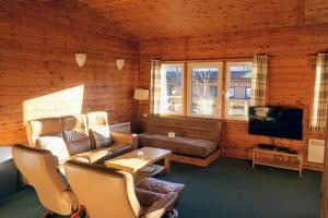 een woonkamer met een bank en een tv bij Woodland Pine Lodge in Killin