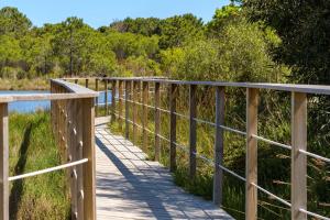 a wooden boardwalk over a body of water at U Paesolu in Sainte-Lucie de Porto-Vecchio