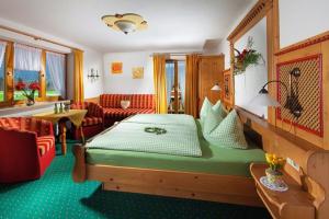 ein Hotelzimmer mit einem Bett und einem Sofa in der Unterkunft Triembachhof in Schönau am Königssee