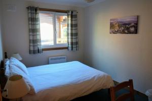a small bedroom with a bed and a window at Woodland Gean Lodge in Killin