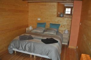 1 dormitorio con 1 cama en una cabaña de madera en Eco Gite La Grange en Fos