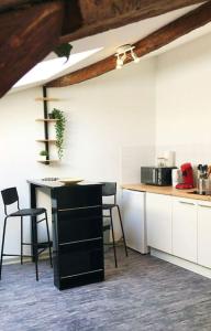 une cuisine avec un comptoir, une table et des chaises dans l'établissement STUDIO LE NID, à Valence