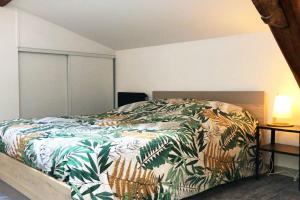 - une chambre avec un lit et une couette colorée dans l'établissement STUDIO LE NID, à Valence