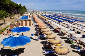 una vista panoramica su una spiaggia con ombrelloni blu e bianchi di Homiday - Holiday Rendez Vous a Pineto