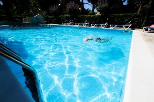 eine Person, die in einem Pool schwimmt in der Unterkunft Homiday - Holiday Rendez Vous in Pineto