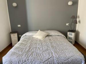 1 dormitorio con 1 cama con almohada y 2 mesitas de noche en La Scuderia en Sarzana