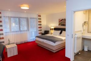 sypialnia z łóżkiem i czerwonym dywanem w obiekcie Gasthof Eyachperle w mieście Haigerloch