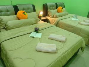 dwa łóżka z ręcznikami na nich w pokoju w obiekcie Cyber Loft Homestay w mieście Ipoh