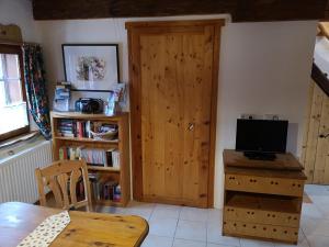 ein Wohnzimmer mit einer Holztür und einem TV in der Unterkunft Ferienhaus FRIEDLHOF in Langschlag