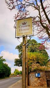 una señal para una casa de cultivo al lado de una carretera en The Crown House Inn en Great Chesterford