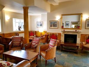 a waiting room with chairs and a fireplace at Crown House Hotel in Great Chesterford