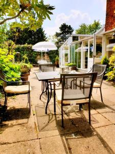 een tafel en stoelen met een parasol op een patio bij The Crown House Inn in Great Chesterford