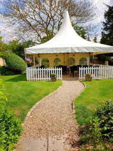 une tente blanche avec un toit blanc dans une cour dans l'établissement The Crown House Inn, à Great Chesterford