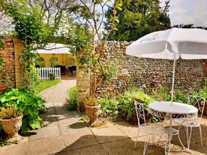 a table and an umbrella in a garden at Crown House Hotel in Great Chesterford