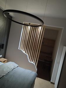a chandelier hanging over a bed in a room at STUDIO APARTMAN BAROSSA in Vinkovci