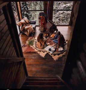 een groep mensen die op de vloer van een hut zitten bij 4 Mountains Hotel in Bystrets