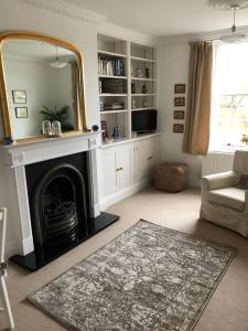 ein Wohnzimmer mit Kamin und Spiegel in der Unterkunft Beautiful riverfront cosy one bedroom apartment in Upton upon Severn