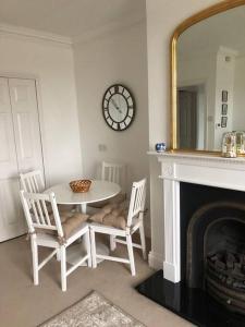 ein Esszimmer mit Tisch und Stühlen und einem Spiegel in der Unterkunft Beautiful riverfront cosy one bedroom apartment in Upton upon Severn + 10 Fotos