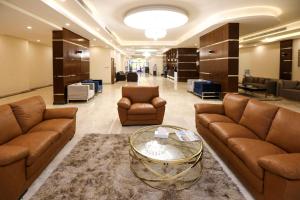 a lobby with couches and a table and chairs at The M Suite in Juffair