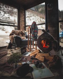 sala de estar con chimenea y ordenador portátil en el suelo en 4 Mountains Hotel en Bystrets