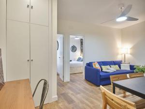 ein Wohnzimmer mit einem blauen Sofa und einem Tisch in der Unterkunft NEW Retiro recién reformado 10 min en metro a Sol, hasta seis personas in Madrid