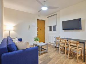ein Wohnzimmer mit einem blauen Sofa und einem Tisch in der Unterkunft NEW Retiro recién reformado 10 min en metro a Sol, hasta seis personas in Madrid