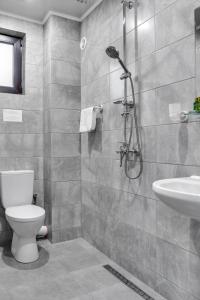 La salle de bains est pourvue d'une douche, de toilettes et d'un lavabo. dans l'établissement Family Hotel LILIUM, à Kirkovo