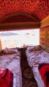 a bedroom with two beds and a window at Walid Bedouin Camp in Wadi Rum