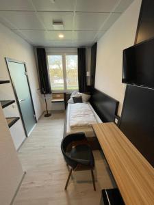 a room with a bed and a table and a tv at Yebs Hotel in Günzburg